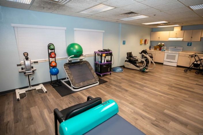 An indoor gym space equipped with various exercise equipment including a bike, exercise balls, and weights.