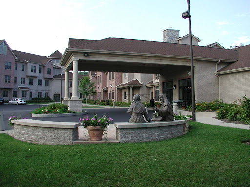 A welcoming residential building featuring a landscaped entrance with sculptures.