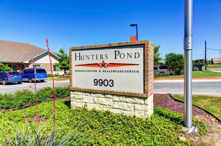 Entrance sign for Hunters Pond Apartments and Townhomes at 9903.
