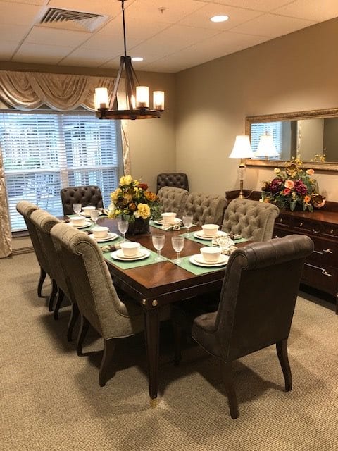 A beautifully set dining table with elegant chairs and lighting.