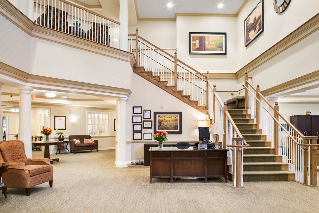 Spacious lobby with a reception desk and staircase.