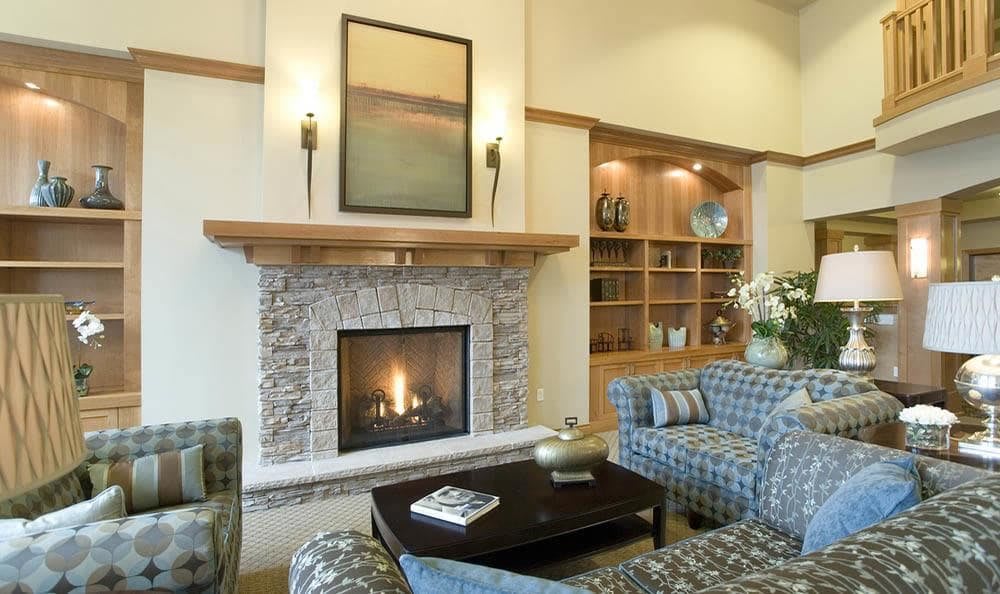 A cozy living room with a stone fireplace and comfortable seating.