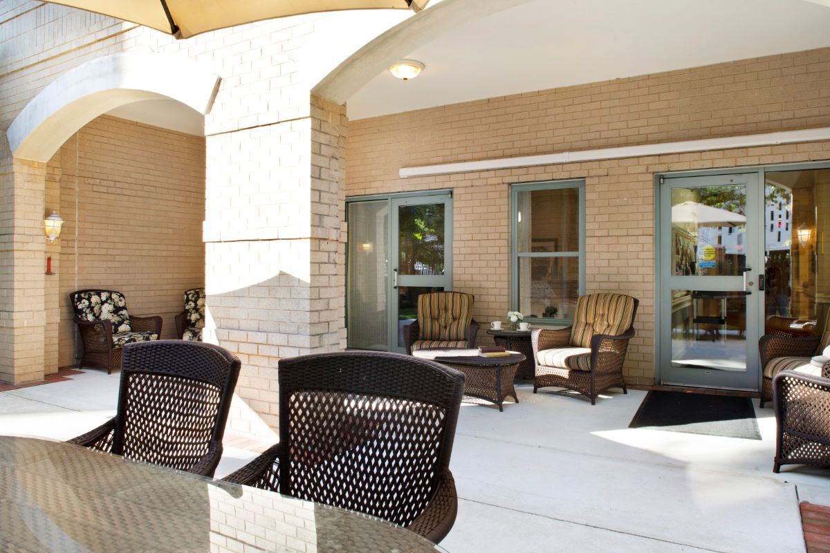 Outdoor patio area with comfortable seating and tables in front of a building.