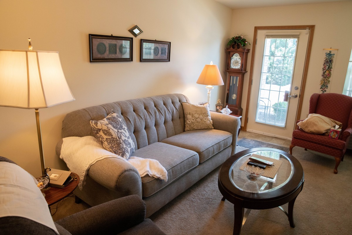 A cozy living room with a comfortable sofa, coffee table, and warm lighting.