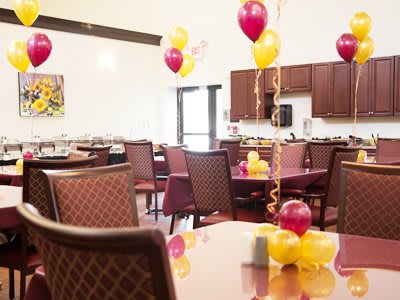 A decorated indoor space with balloons and tables set for an event.