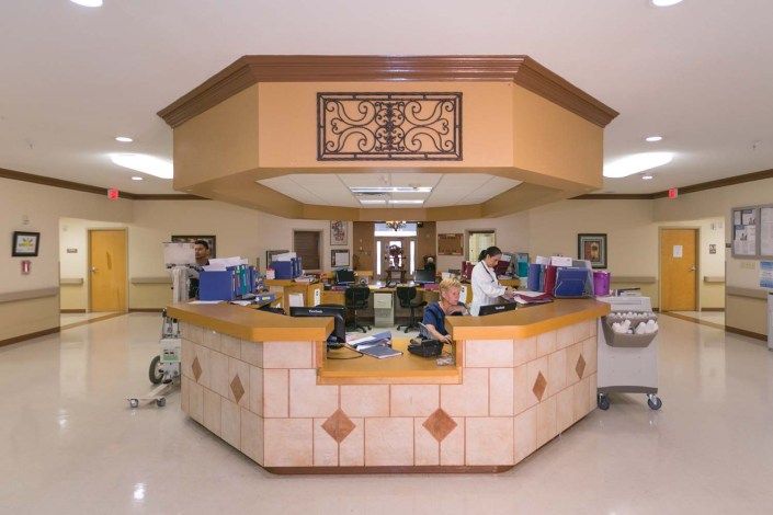 A nurse station in a hospital, equipped with medical supplies and staff working.