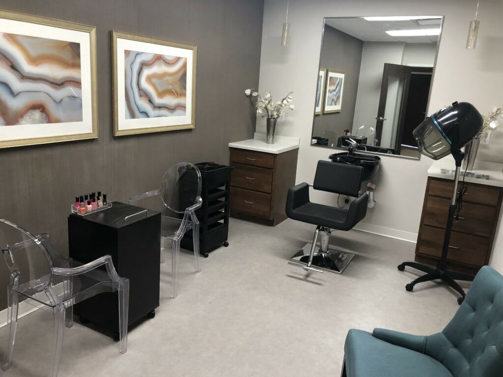 A modern hair salon interior with styling chairs and artwork on the walls.