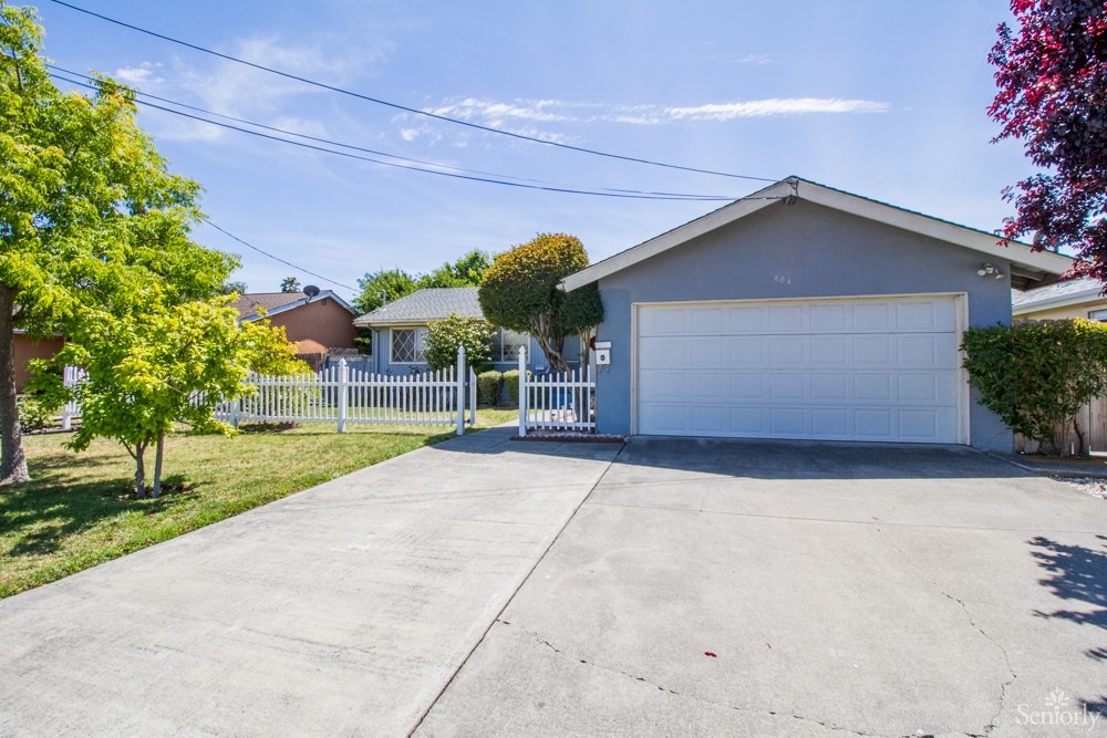 A suburban house with a concrete driveway and attached garage.