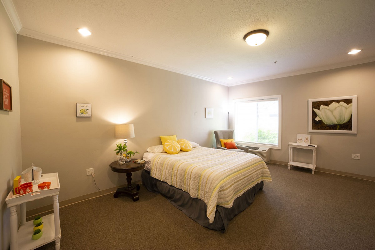 A cozy bedroom with a neatly made bed, soft lighting, and warm decor.