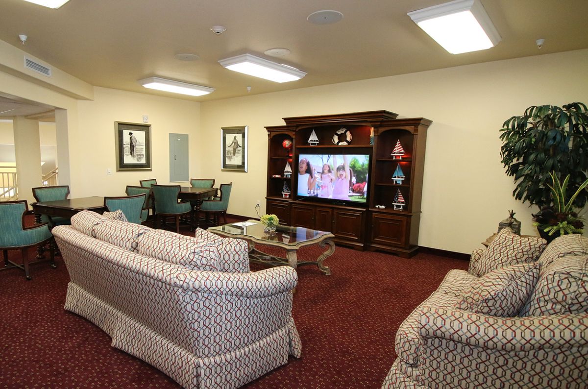 A cozy living room with a television, couches, and furniture, decorated in a warm and inviting style.