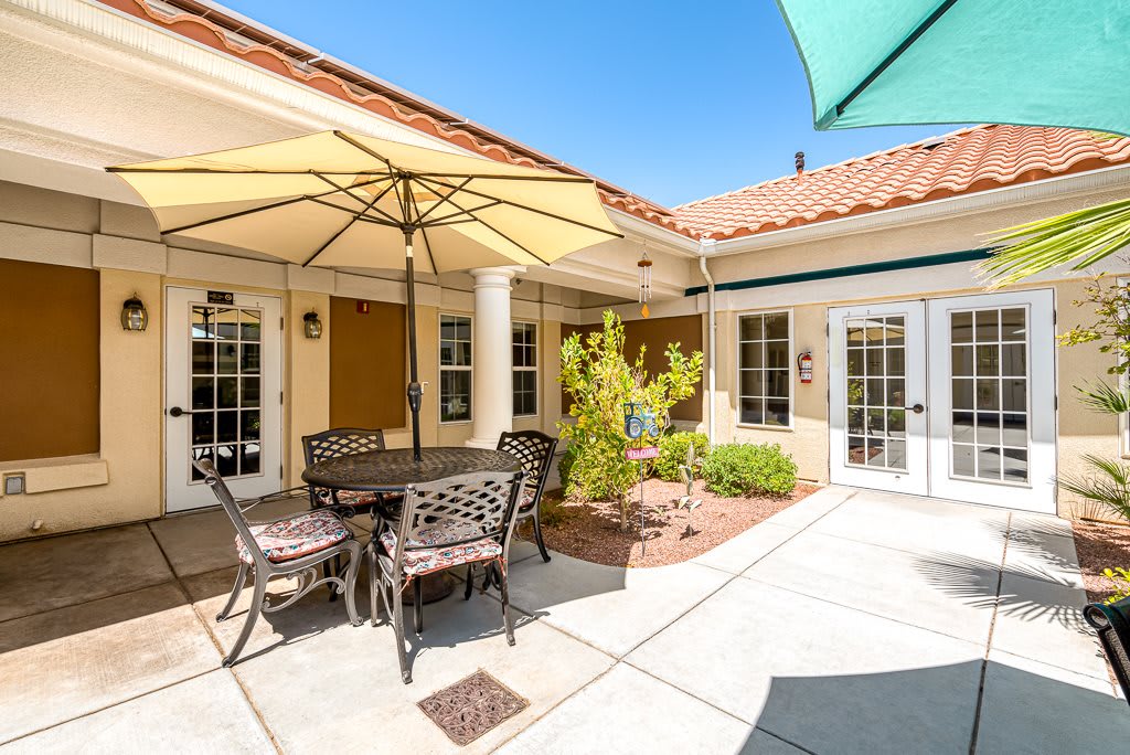 A sunny patio with outdoor seating and umbrellas in a residential courtyard.