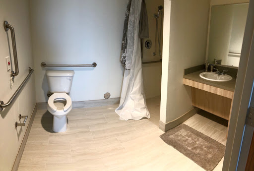 A clean and minimalistic bathroom featuring a toilet, shower area, and sink.