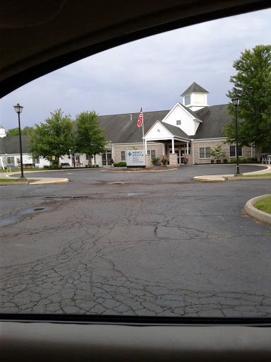 A view of a building from a parking lot under a cloudy sky.