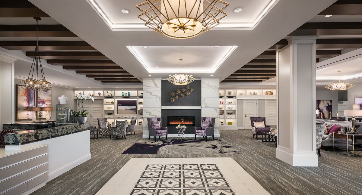 A modern lobby with a stylish fireplace, comfortable seating areas, and a striking chandelier.