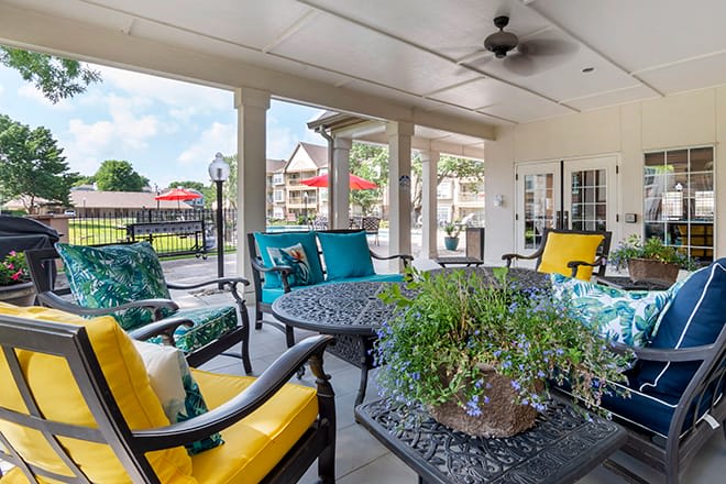 A cozy patio with colorful cushioned seating around a table, perfect for outdoor relaxation.