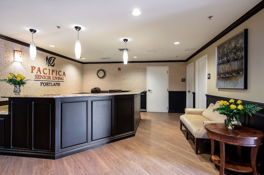 A modern reception area with elegant interior design, featuring a black desk and comfortable seating.