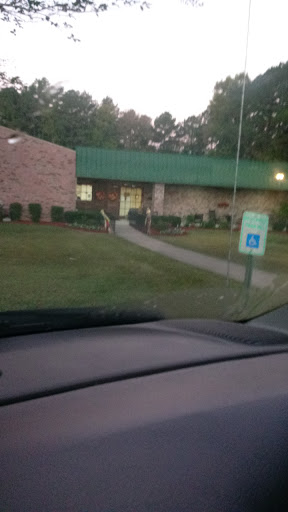 A view of a building with a green roof and handicap accessible entrance during the evening.