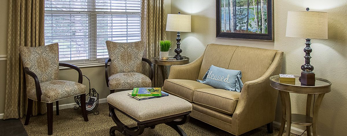 A cozy living room with a comfortable sofa, patterned armchair, and a stylish lamp.