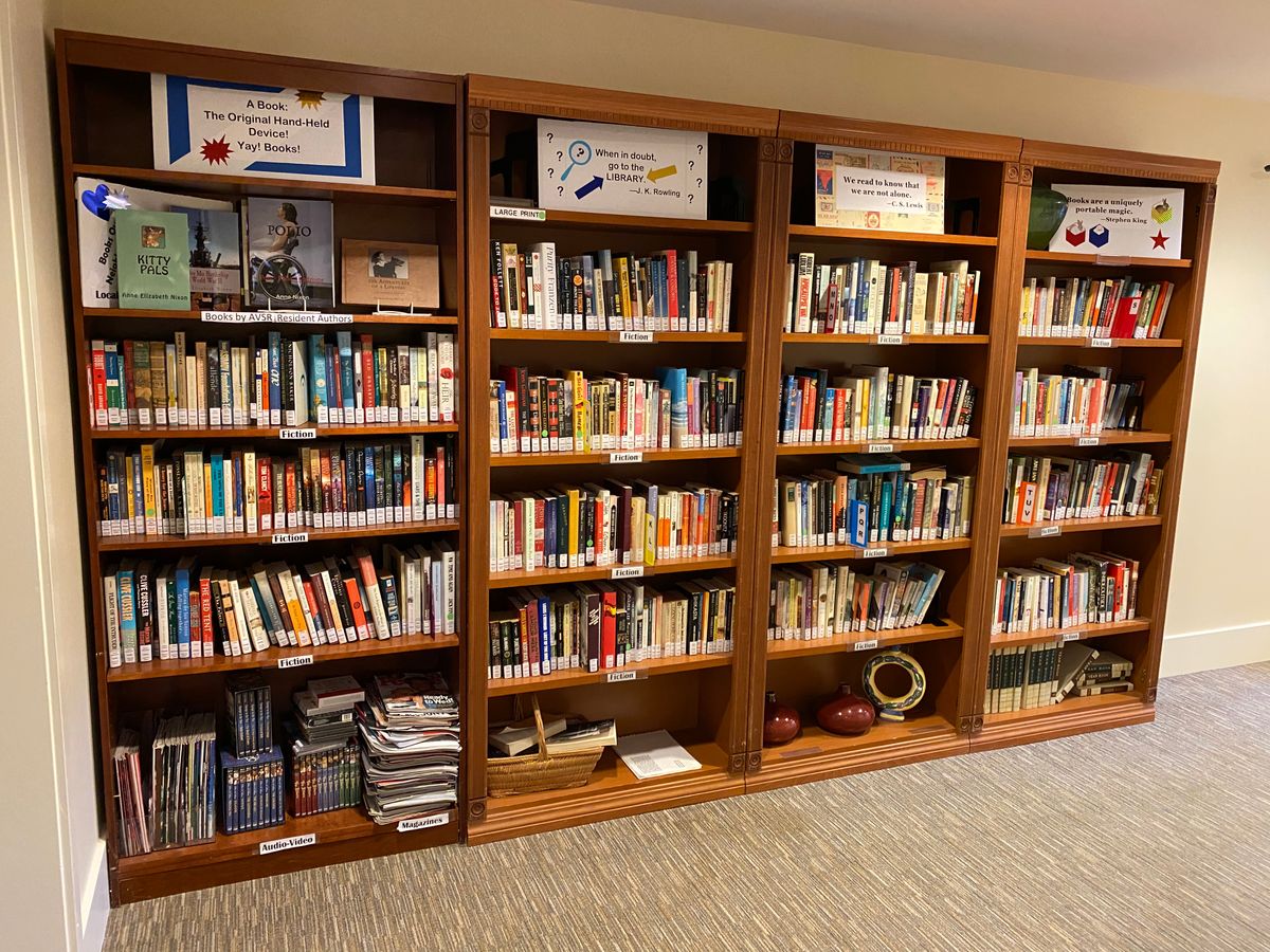 A neatly organized bookshelf filled with a variety of books in a library setting.
