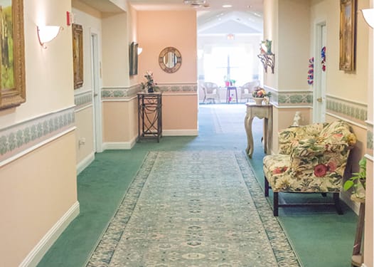 A well-decorated hallway with a green carpet and elegant furnishings.