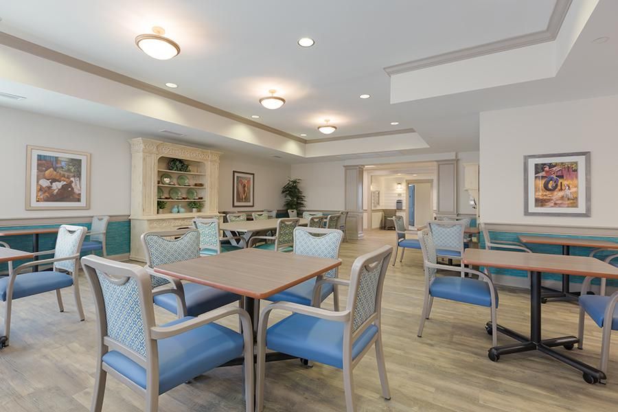 A well-lit dining area with neatly arranged tables and chairs.