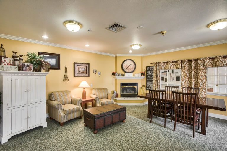 A cozy living room with a sofa and dining area, featuring a fireplace and warm decor.