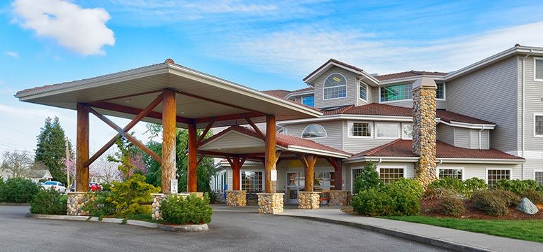 A large, multi-story building with a covered entrance and rustic wooden pillars.