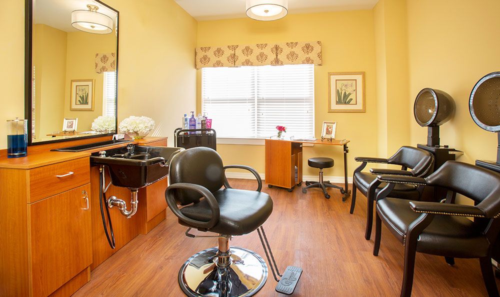 A well-lit hair salon with stylish chairs and a mirror.