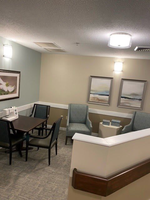 A cozy waiting area with a table, chairs, and wall artwork.