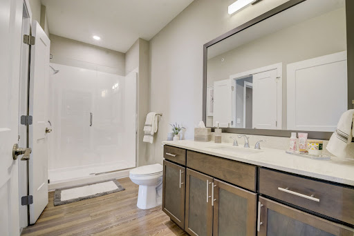 A modern bathroom featuring a spacious shower, elegant vanity, and tasteful decor.