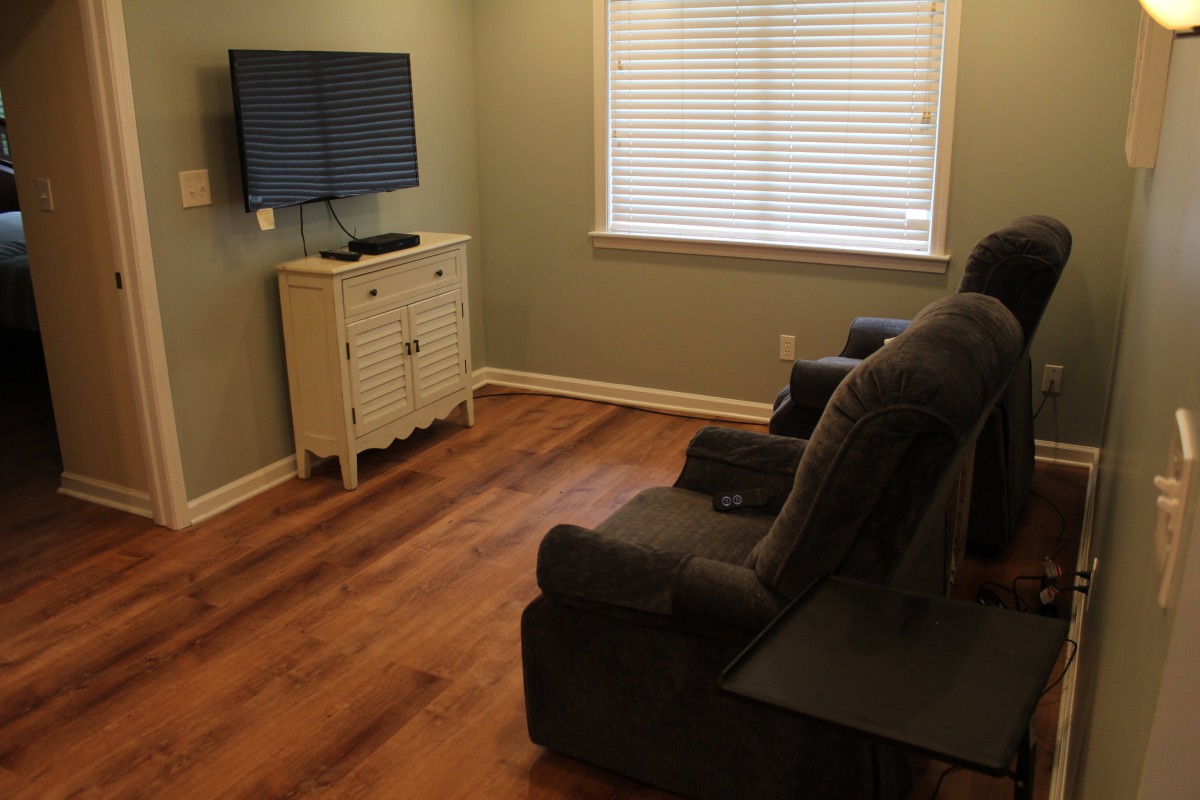 A cozy living room with recliner chairs and a TV.