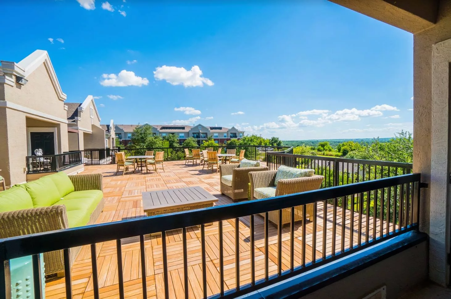 A sunny rooftop with outdoor seating and a scenic urban view.