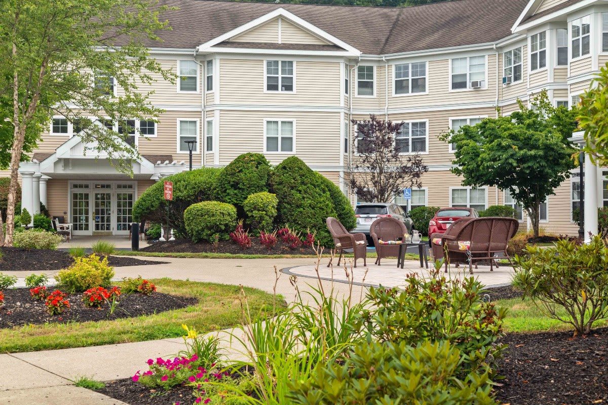 A well-maintained residential building with a landscaped garden and outdoor seating area.