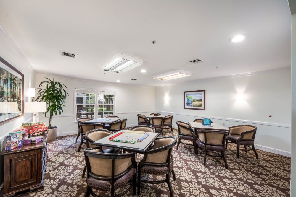 A well-lit game room with multiple tables set up for board games.