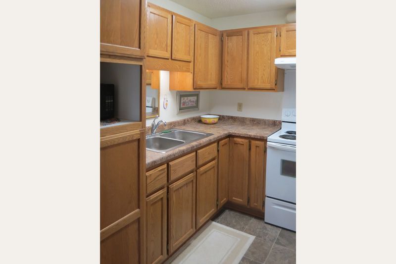 Compact kitchen with wooden cabinets and appliances.