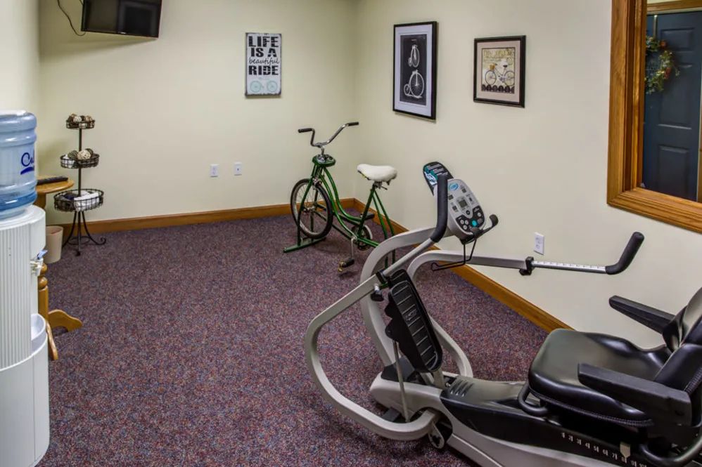 A small exercise room with fitness equipment including a stationary bike and exercise machine.