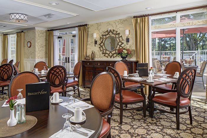 An elegant dining room with neatly arranged tables and chairs, featuring classic interior decor.
