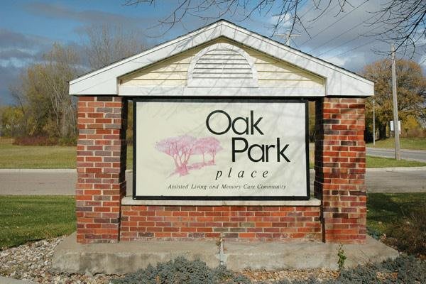 A brick sign displaying 'Oak Park Place' outdoors.