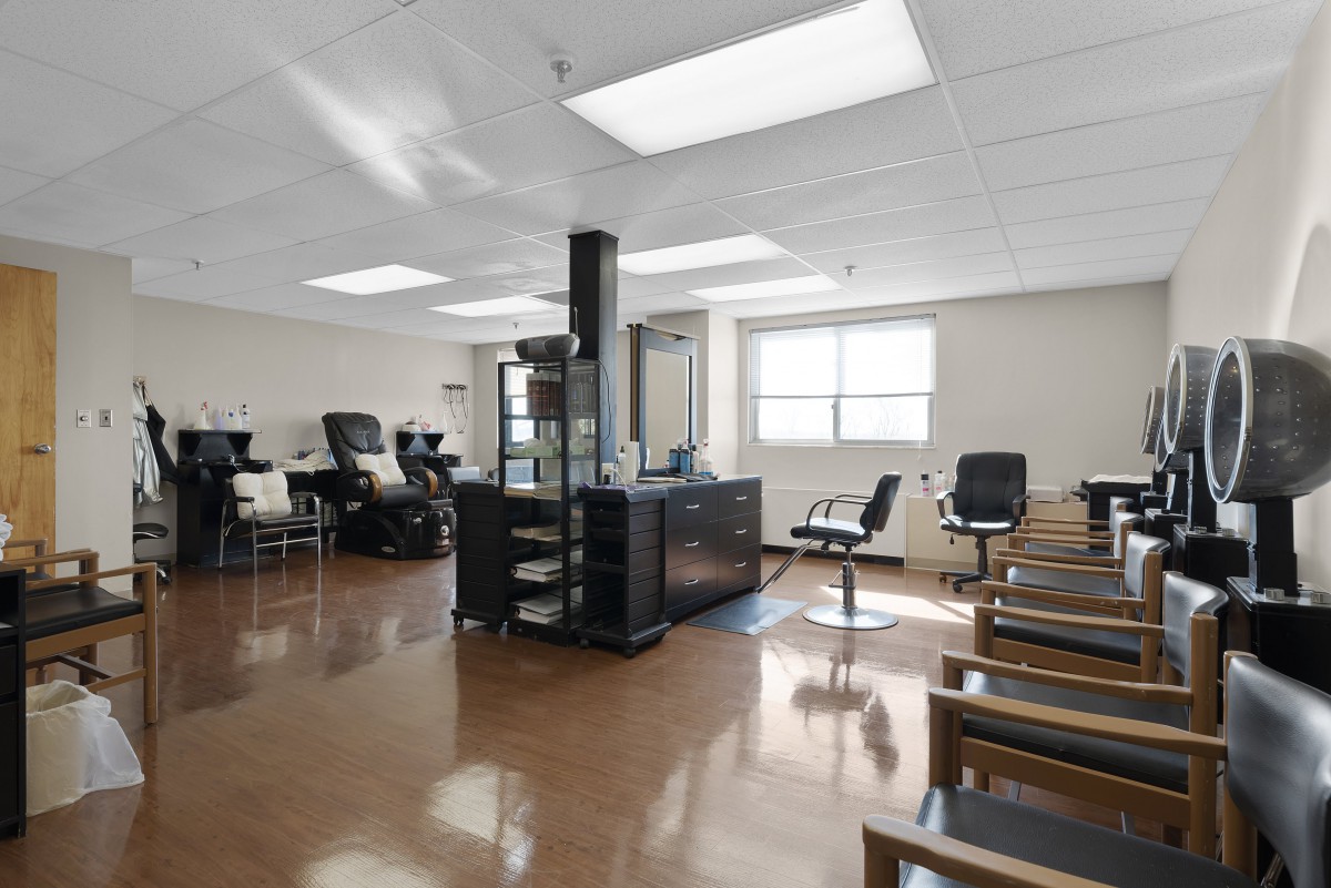 A modern, empty hair salon interior with chairs and mirrors.