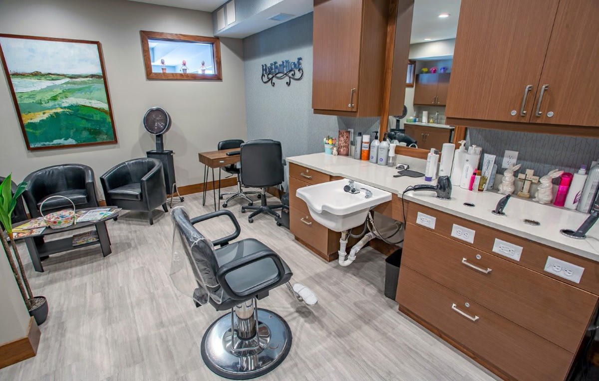 A modern hair salon interior featuring a styling chair, sink, and various hair products.