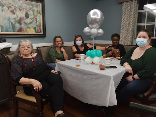 A joyful gathering of friends celebrating together with balloons and smiles.