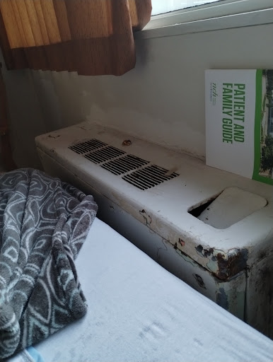 A heating unit next to a bed, showcasing a cozy bedroom setup.
