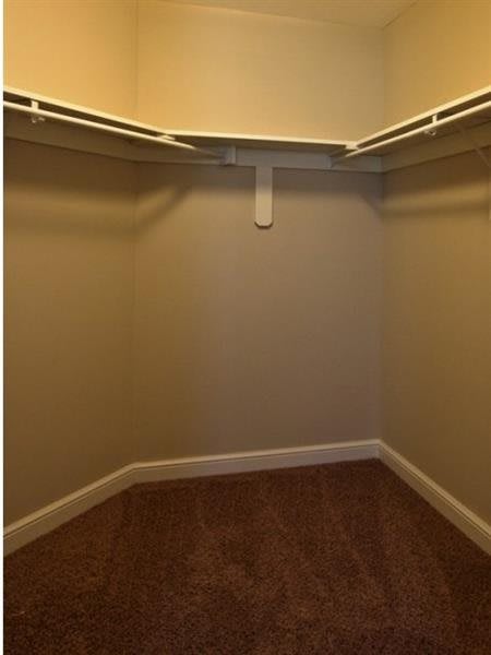 An empty walk-in closet with shelving installed.
