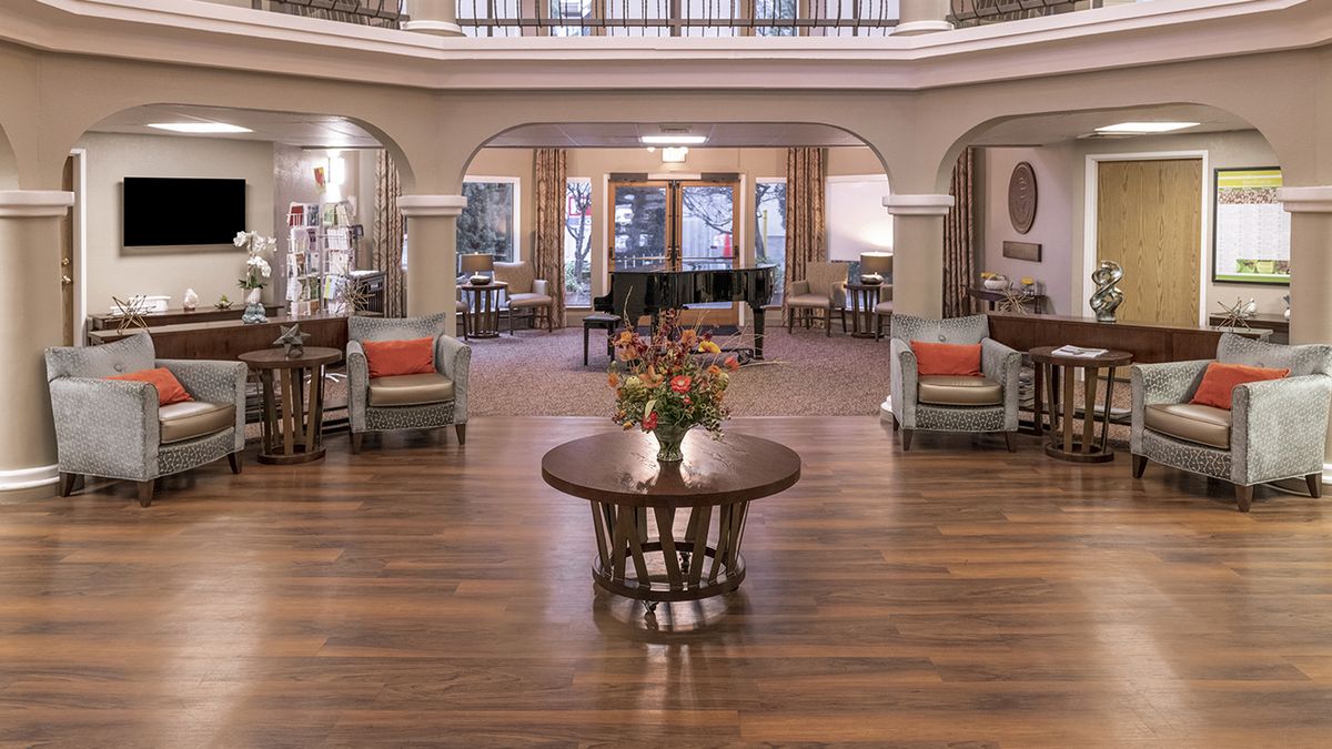 A spacious and elegantly decorated lobby featuring a grand piano and floral centerpiece.