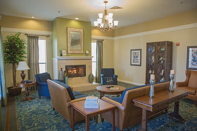 A cozy living room with a fireplace, surrounded by comfortable seating and elegant decor.