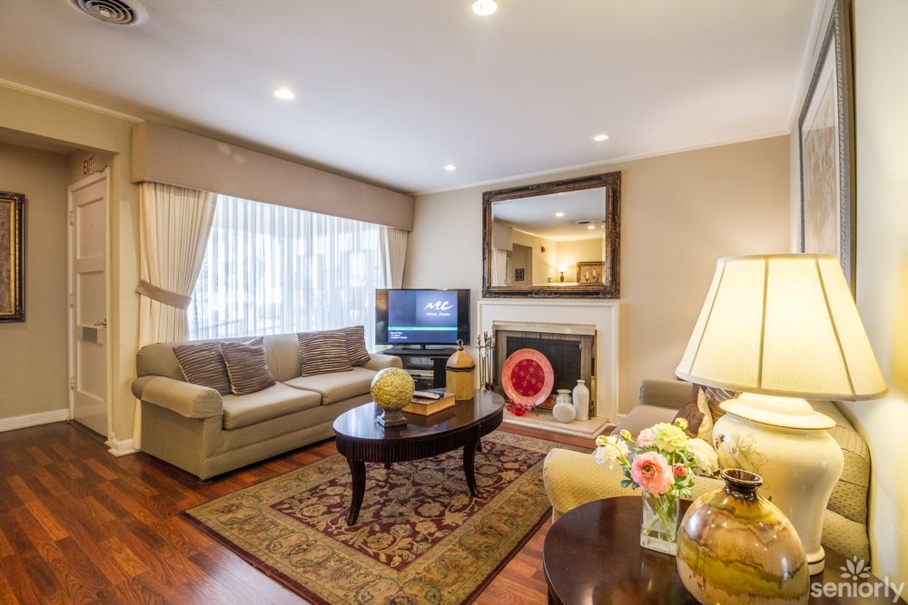 A cozy living room with a sofa, fireplace, and television for relaxation.