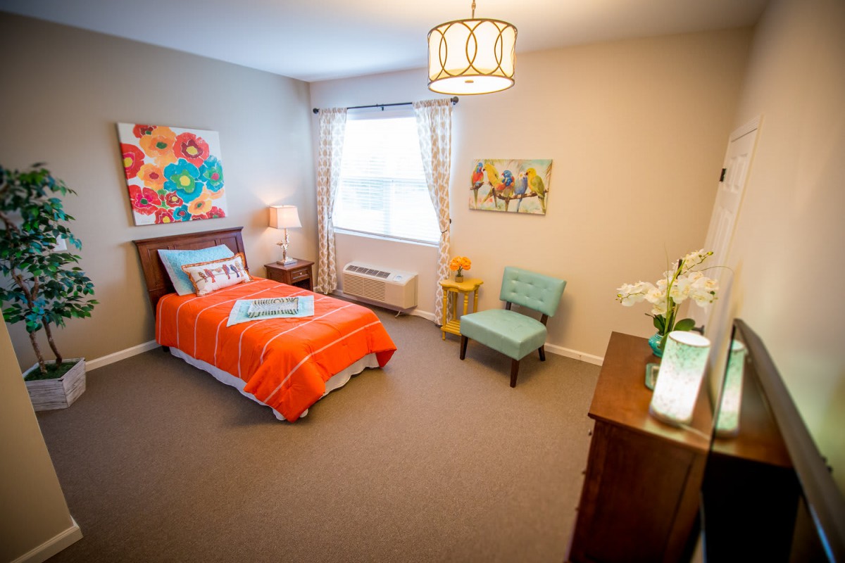 A cozy bedroom with a single bed adorned with colorful bedding and modern decor.