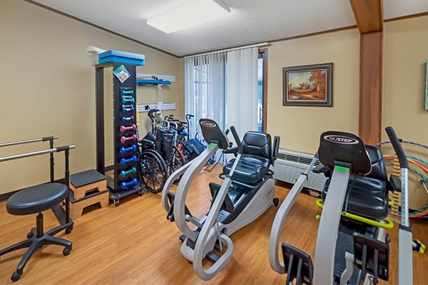 A small home gym with various exercise equipment, including bicycles and weights.