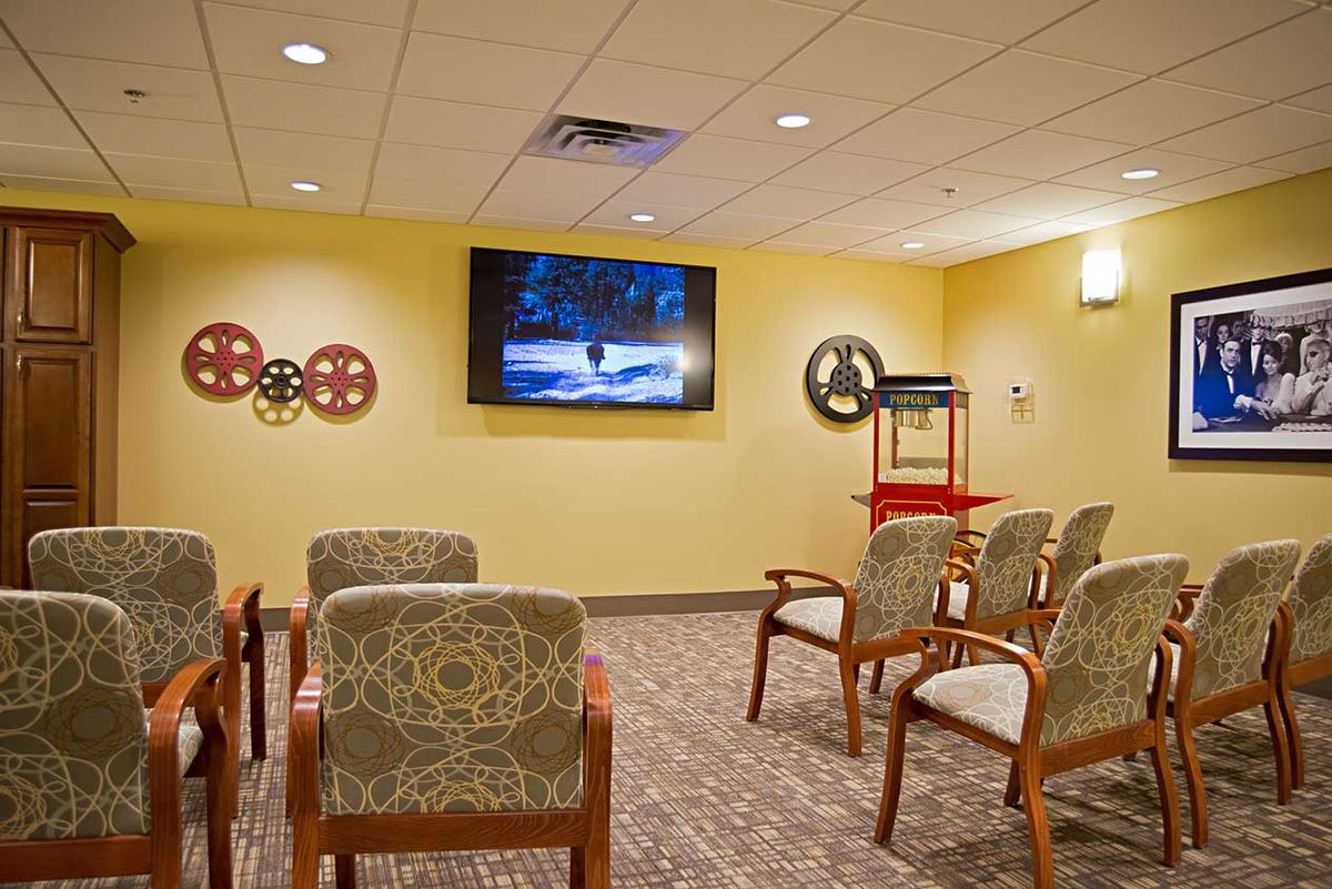 A cozy waiting room with chairs facing a television on the wall.