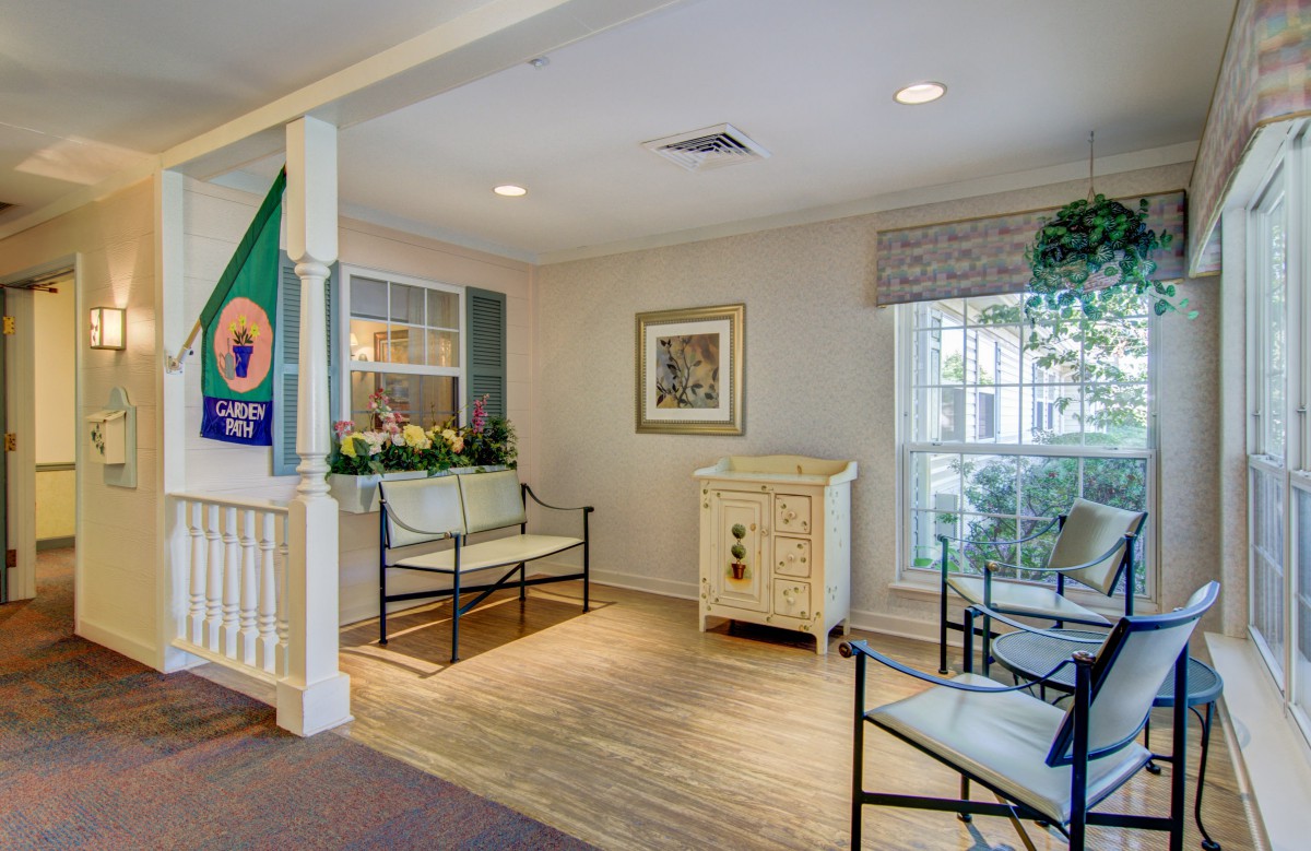 A cozy waiting area with seating and bright lighting, featuring decorative elements.